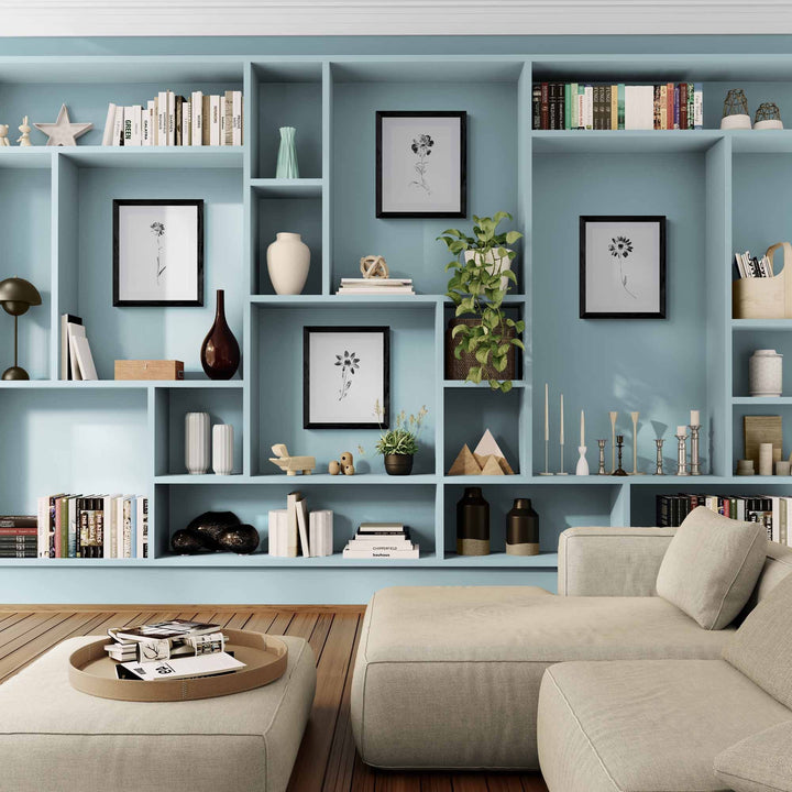 black and white floral gallery wall in blue bookshelves in living room